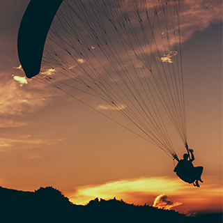 A man paragliding - by Lucas Mordzin