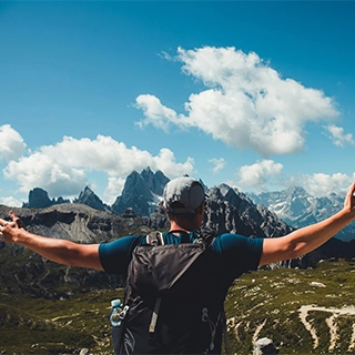 Man standing on mountain under blue sky and white - by Anders Nielsen