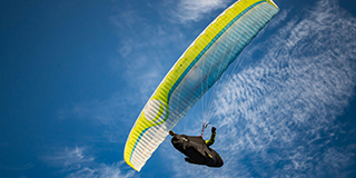 Person on yellow and white parachute - by Viktor Vasicsek